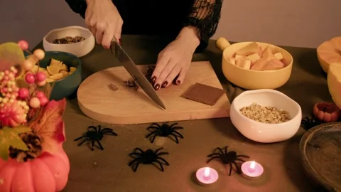 Chocolate bar is being diced with a large knife kitchen table set for homemade Stock Footage 318937612
