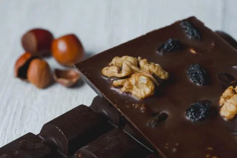 Chocolate bar filled with different berries and nuts close-up  lie old wooden Stock Photos