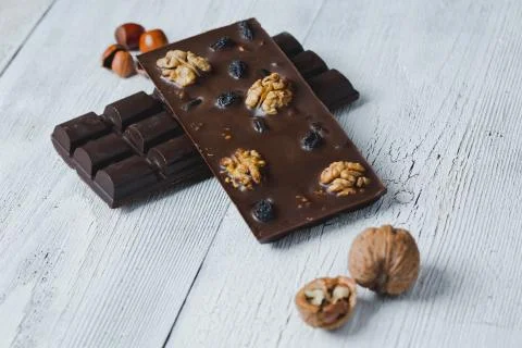 Chocolate bar filled with  nuts close-up  lie old wooden table with cracked p Stock Photos