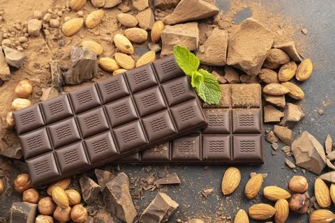 Chocolate bar with hazelnuts, mint leaf, handmade sweets. Composition of bars Stock-Fotos