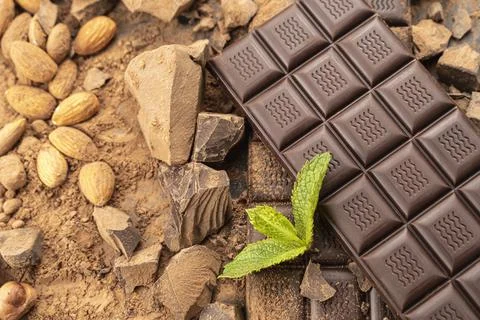 Chocolate bar with hazelnuts, mint leaf, handmade sweets. Composition of bars Stock Photos
