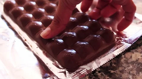 Chocolate Bar with mint bubbles inside with hand breaking part of it Stock Footage 49433320