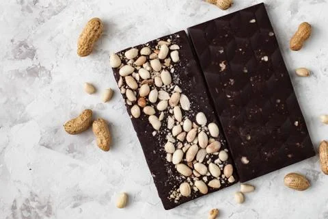 Chocolate bar with nuts lying on the table Stock Photos