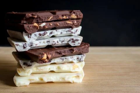 Chocolate bar stack on wooden background. Stock Photos