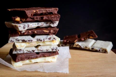 Chocolate bar stack on wooden background. Stock Photos