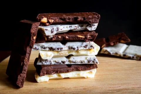 Chocolate bar stack on wooden background. Stock Photos