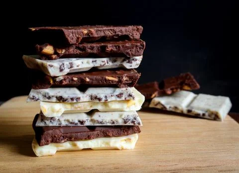 Chocolate bar stack on wooden background. Stock Photos