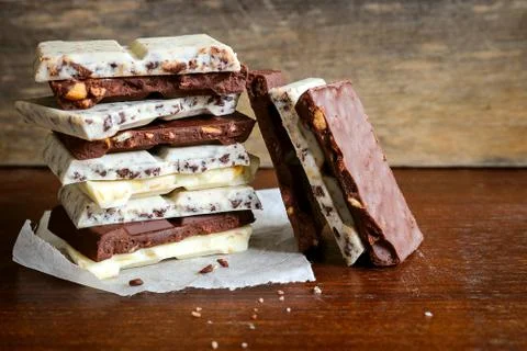 Chocolate bar stack on wooden background. Stock Photos