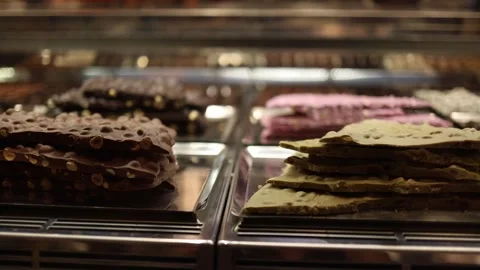 Chocolate bark stacks loaded with crunchy nuts and bold flavors sit temptingly i Stock Footage 310056101