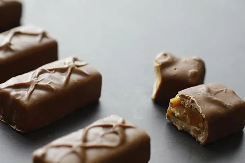 Chocolate bars on a black background in backlight. Chocolate with filling. .. Stock Photos