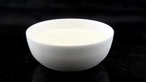 Chocolate Bars Falling on a Plate with Milk in Super Slow Motion Stock Footage 82187580