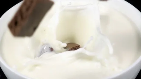 Chocolate Bars Falling on a Plate with Milk in Super Slow Motion Stock Footage 82313613