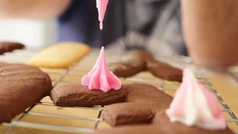 Chocolate biscuit decorated with pink icing Stock Footage 253609959