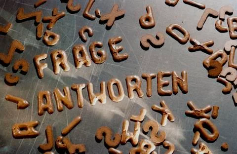 Chocolate biscuits used to spell 'question' and 'answer' in German Fotos Stock
