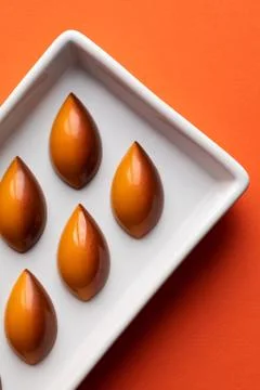 Chocolate bonbons on an orange background Stock Photos