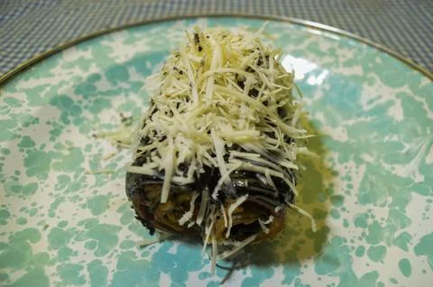 A chocolate bread with tons of cheese on top Stock Photos