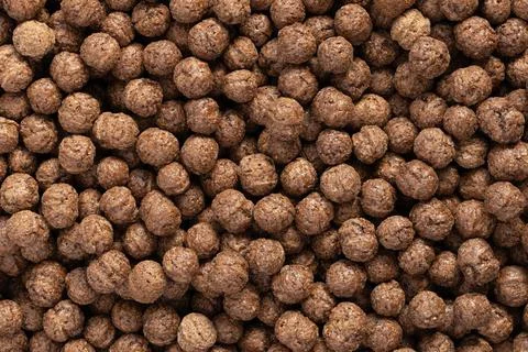 Chocolate breakfast cereal balls texture background. Close-up of cocoa puffed Stock Photos