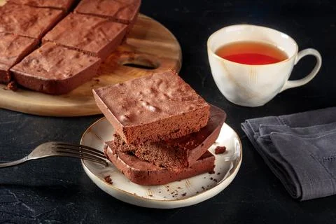 Chocolate brownie with tea, simple coffee cake, on a black slate background 写真素材