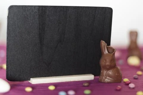 Chocolate bunny missing a bite and blackboard with copy space Foto stock