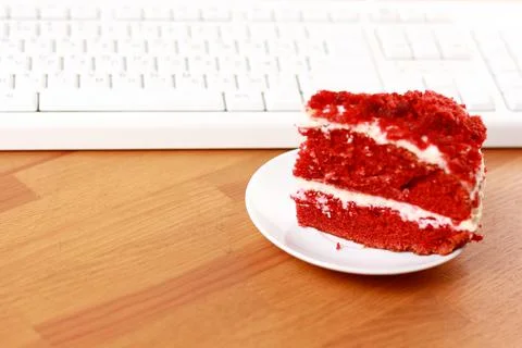 Chocolate cake and a computer keyboard. Stock Photos