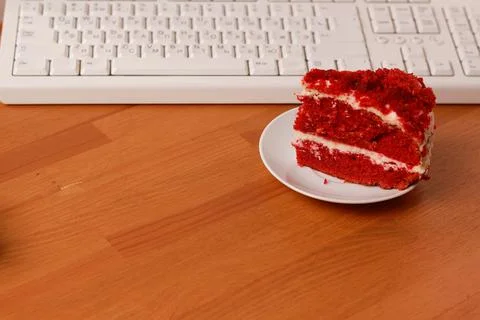Chocolate cake and a computer keyboard. Stock Photos