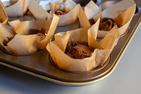 Chocolate cake batter in a paper wrapper in a baking dish Foto stock