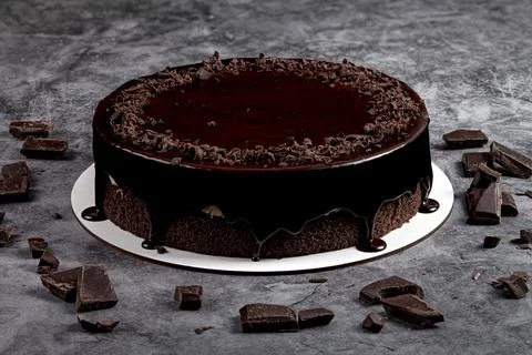 Chocolate cake with black glaze on a grey background 库存照片