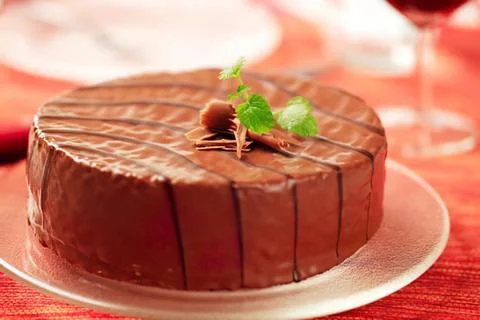 Chocolate cake with cherry and mint garnish Stock Photos