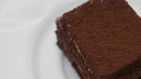 Chocolate cake with cocoa powder, rotating in a white plate Stock Footage 54341590