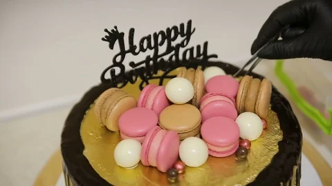 Chocolate cake covered with different colourful cookies, macaroons and candy for Stock Footage 129460785