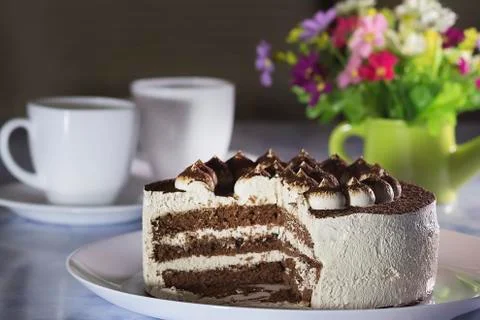 Chocolate Cake with Cream and Two  White Cups of Coffee . Stockfoto's