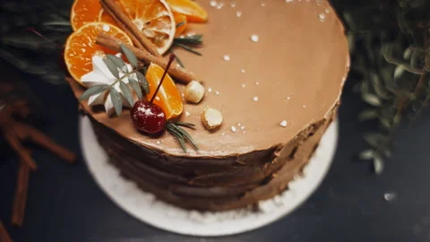 A chocolate cake on a dark background adorned with citrus and rosemary. Stock-Footage 86368363