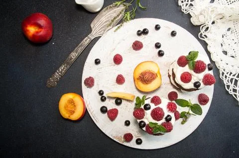 Chocolate cake decorated with raspberry, black currant, nectarine, wipped cre Stock Photos