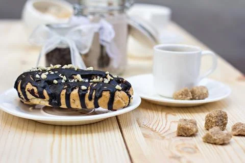 Chocolate cake (eclair) with cup of coffee. profiteroles with chocolate cream Stock Photos