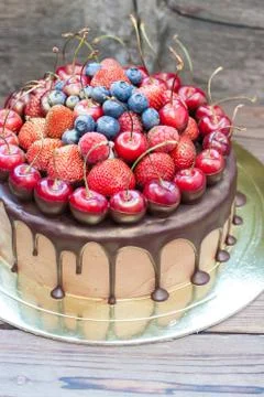 Chocolate cake with fresh cherries, strawberries, raspberries and blueberries Stock Photos