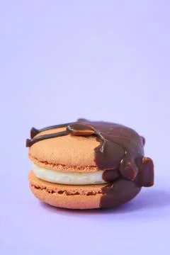 Chocolate Cake macaron or macaroon on purple background. Stock Photos