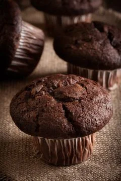 Chocolate cake muffins on a table. Dark lighting Stock Photos