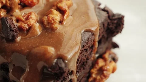 Chocolate cake with nuts and salted caramel. Delicious brownies on a plate. Stock Footage 335140473