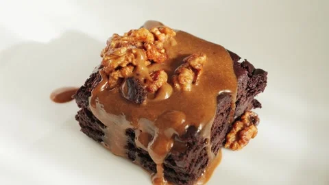 Chocolate cake with nuts and salted caramel. Delicious piece of cake brownie on Stock Footage 335140595