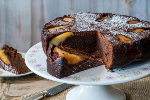 Chocolate cake with pears dusted with icing sugar Stock Photos