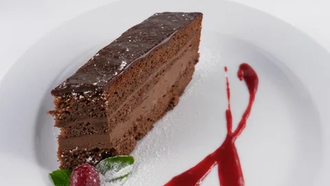 Chocolate cake slice in plate, served in restaurant Stock Footage 79985254