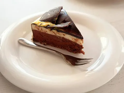 Chocolate cake slice on white plate with fork Stock Photos