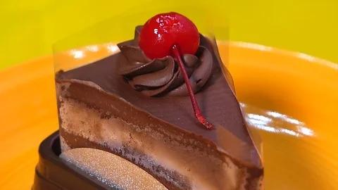 Chocolate cake square Spin on orange palette Stock Footage 74202360