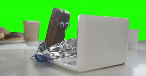 Chocolate candy bar using laptop. Watching content about sugar. Green screen Stock Footage 237036518