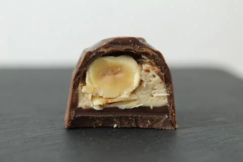 Chocolate candy with praline white filling and hazelnut hazelnut in section.  Stock Photos