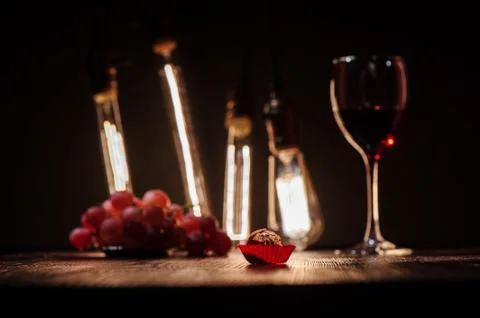 Chocolate candy in a red wrapper on a dark wooden table against the backgroun Stockfoto's