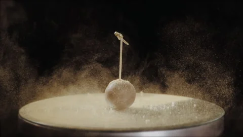 Chocolate candy on the round mirror,a cloud of golden confectionery dust Video stock 149147902