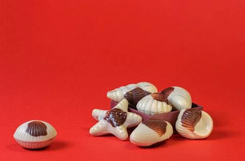 Chocolate candy shells on red background Foto stock