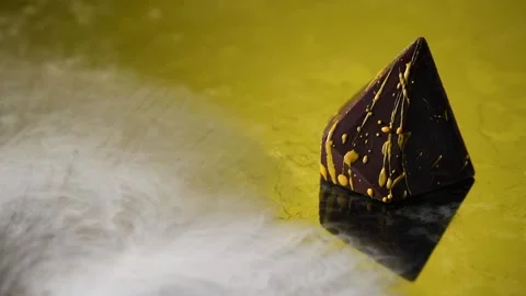 Chocolate candy in a smoke on a golden background. Stock Footage 132043984