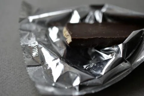 Chocolate candy in a wrapper on a gray background Stock Photos
